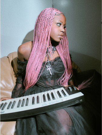 A person with pink hair holding a keyboard.