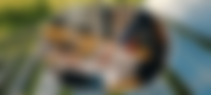 A close-up of people pointing at a paper, overlaid on a photo of solar panels.