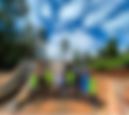 A group of men in safety vests and helmets standing in front of a concrete dam.