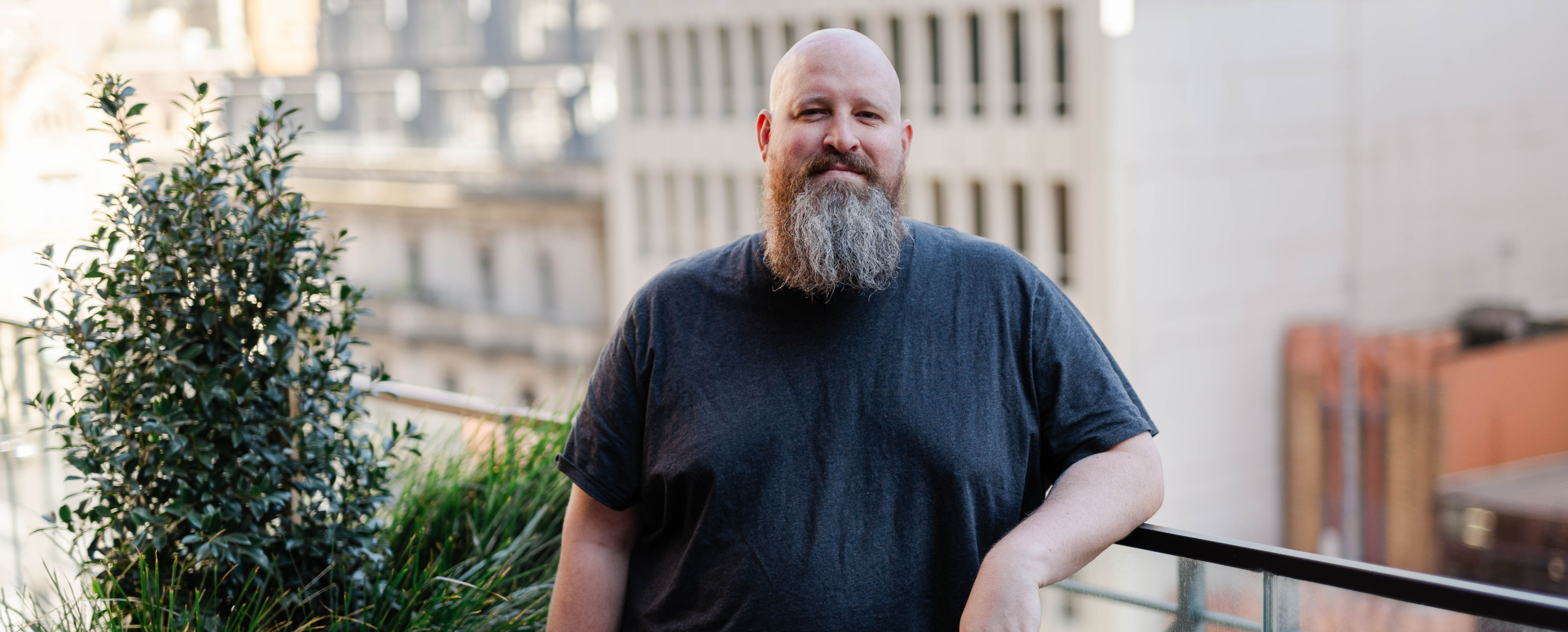 A person with a beard poses for a photo.