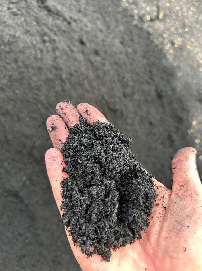 A hand holding a pile of dirt.