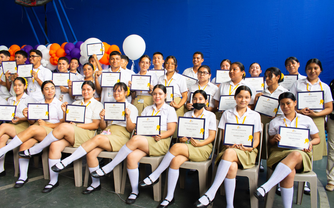 A group of children poses with their graduation certificates.