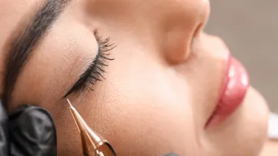 Nahaufnahme einer Permanent-Make-up-Behandlung für Eyeliner in Berlin, die ein präzises kosmetisches Tattoo entlang des Wimpernkranzes zeigt