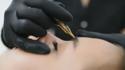 Nahaufnahme einer nicht-laserbasierten dauerhaften Entfernung von Augenbrauen-Make-up in Berlin mit professioneller Tätowiermaschine
