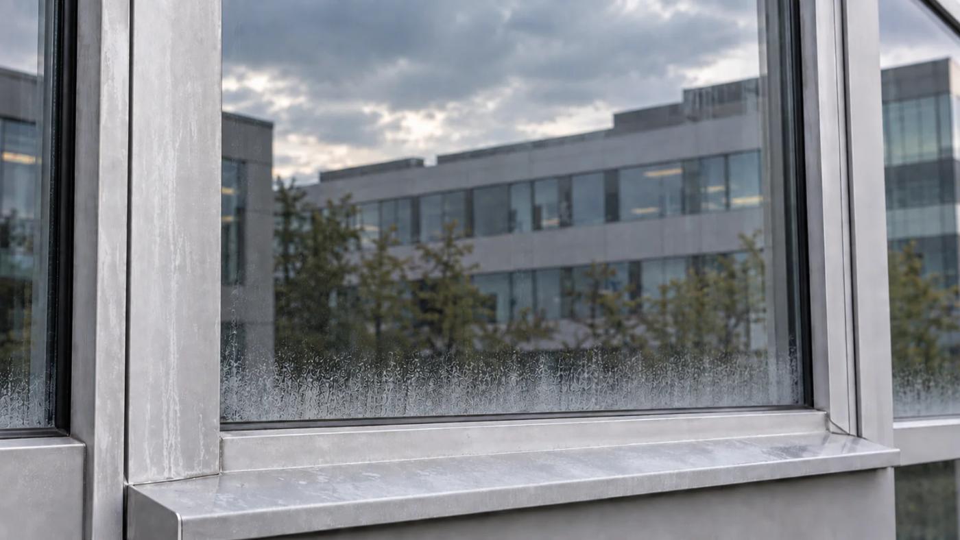 Vindu og fasadeplate i glass og metall på næringsbygg med skade på glasset