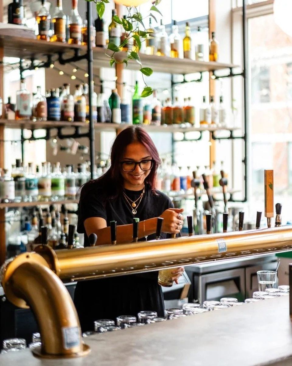 Une barmaid derrière le bar de La Buvette du Centro