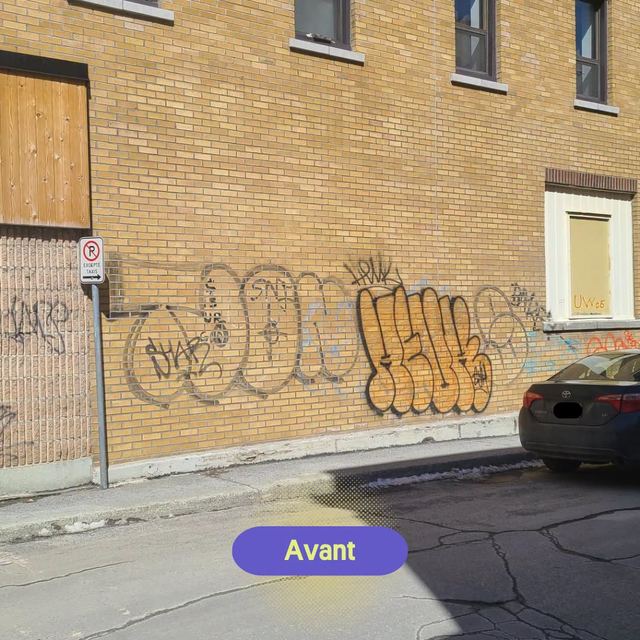 Mur de brique jaune couvert de graffitis dans une rue du centre-ville, avant le nettoyage