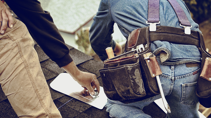 Installer measuring a mount point on the roof