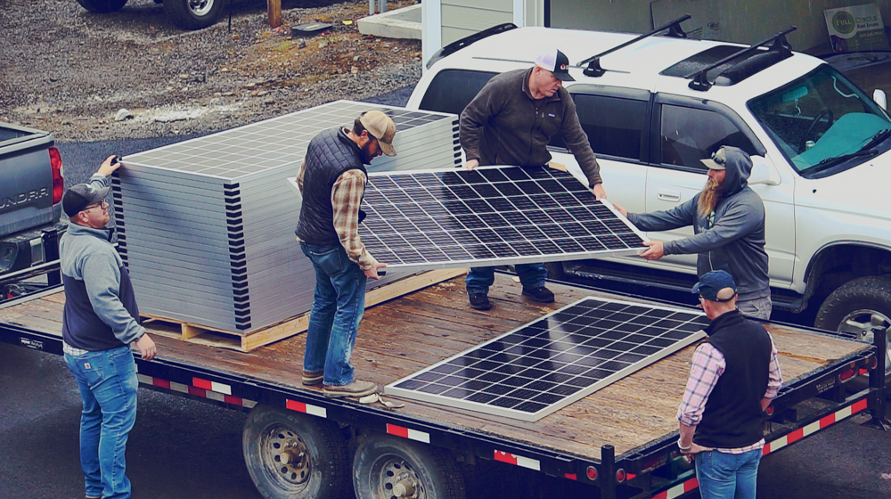 Crew unloading solar panels at a job site