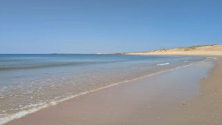 Stunning sand and calm waves at Plage Naturiste du Petit Pont