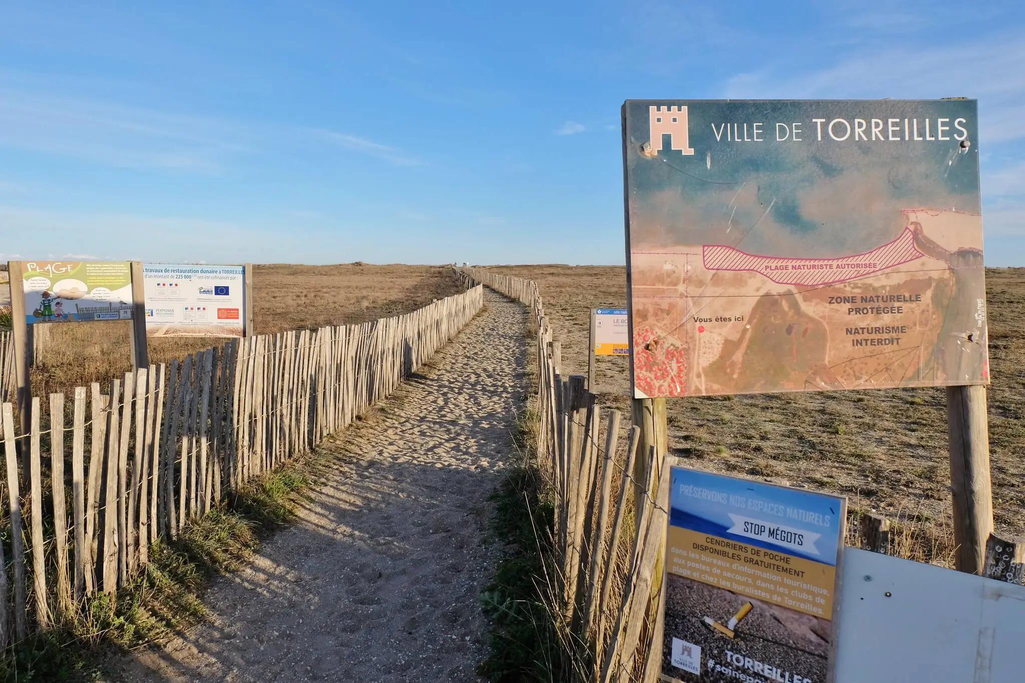 Entrance to nude beach with a map and info
