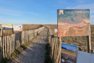 Entrance to nude beach with a map and info