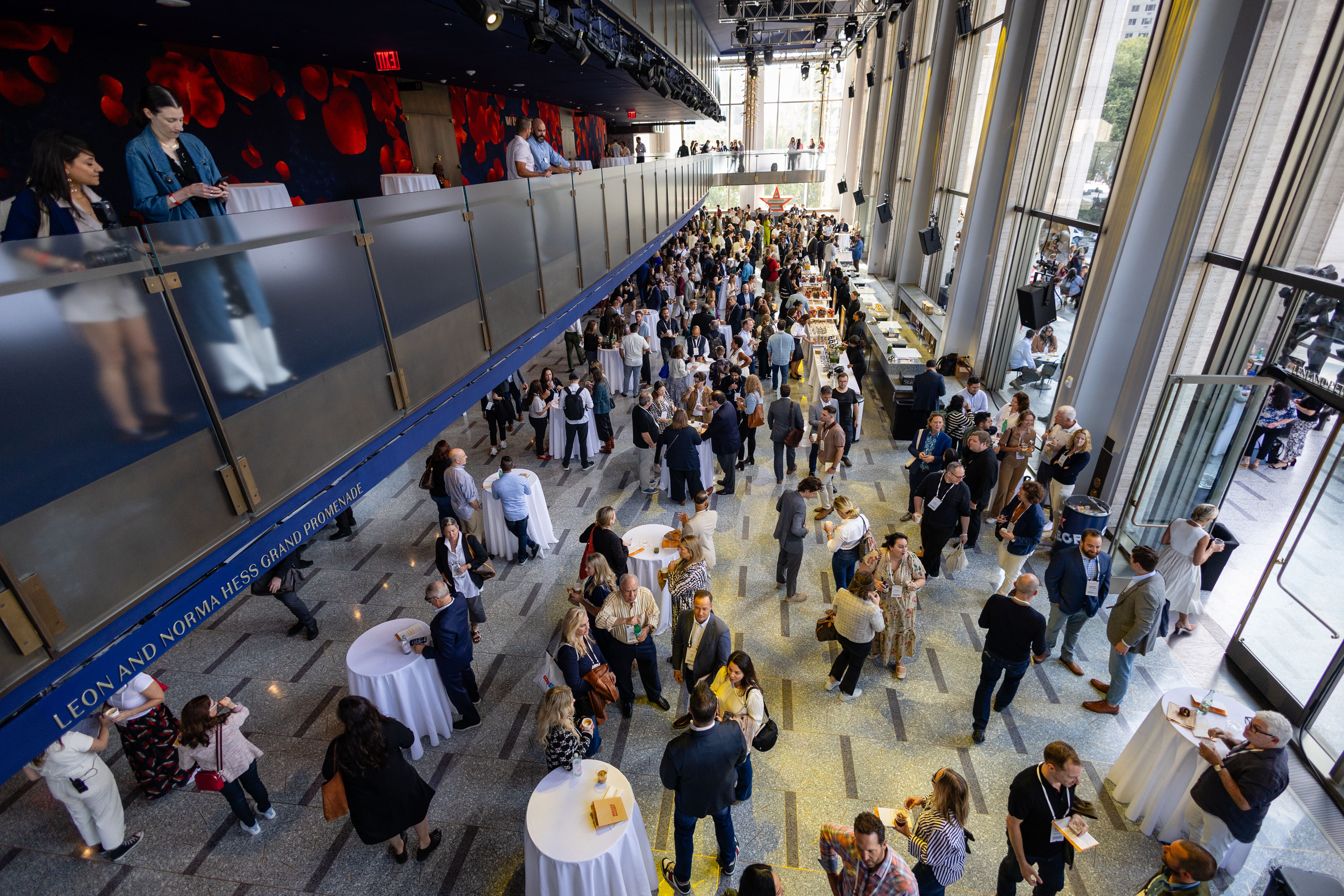 Overhead shot of the lobby spaces at David Geffen Hall, full of people mingling at Welcome