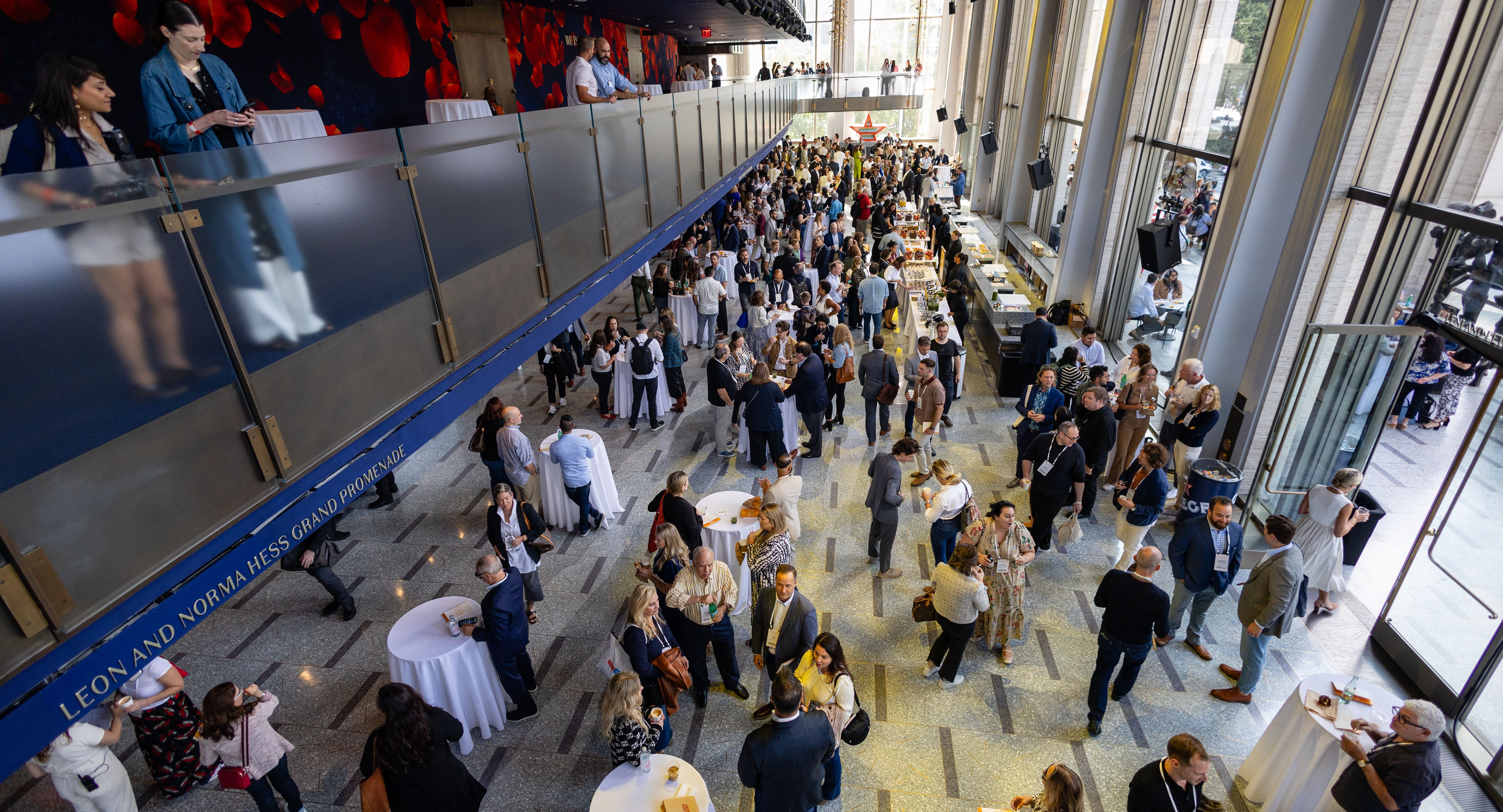 Overhead shot of the lobby spaces at David Geffen Hall, full of people mingling at Welcome