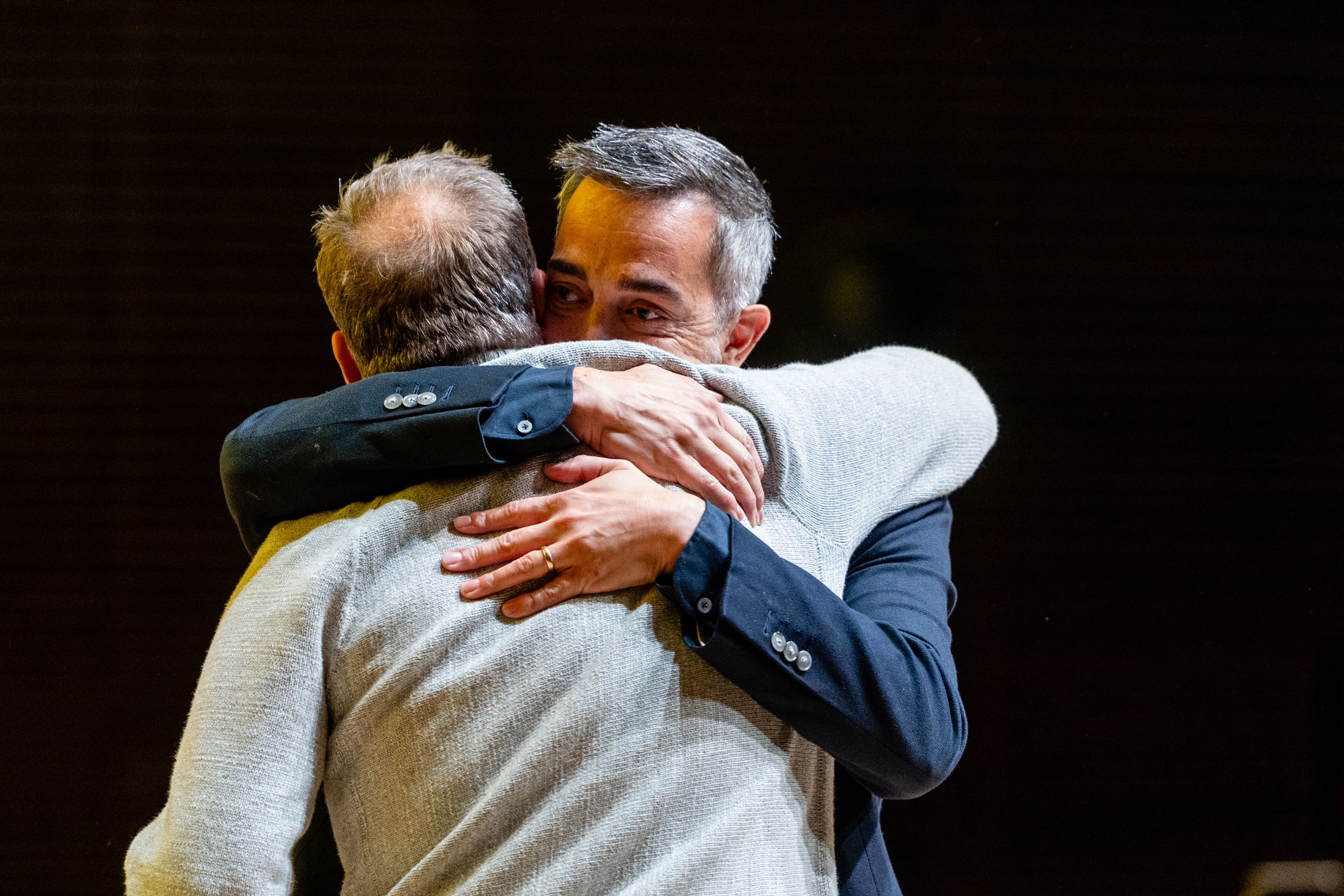 Brian Canlis hugging Don Miller onstage at Welcome