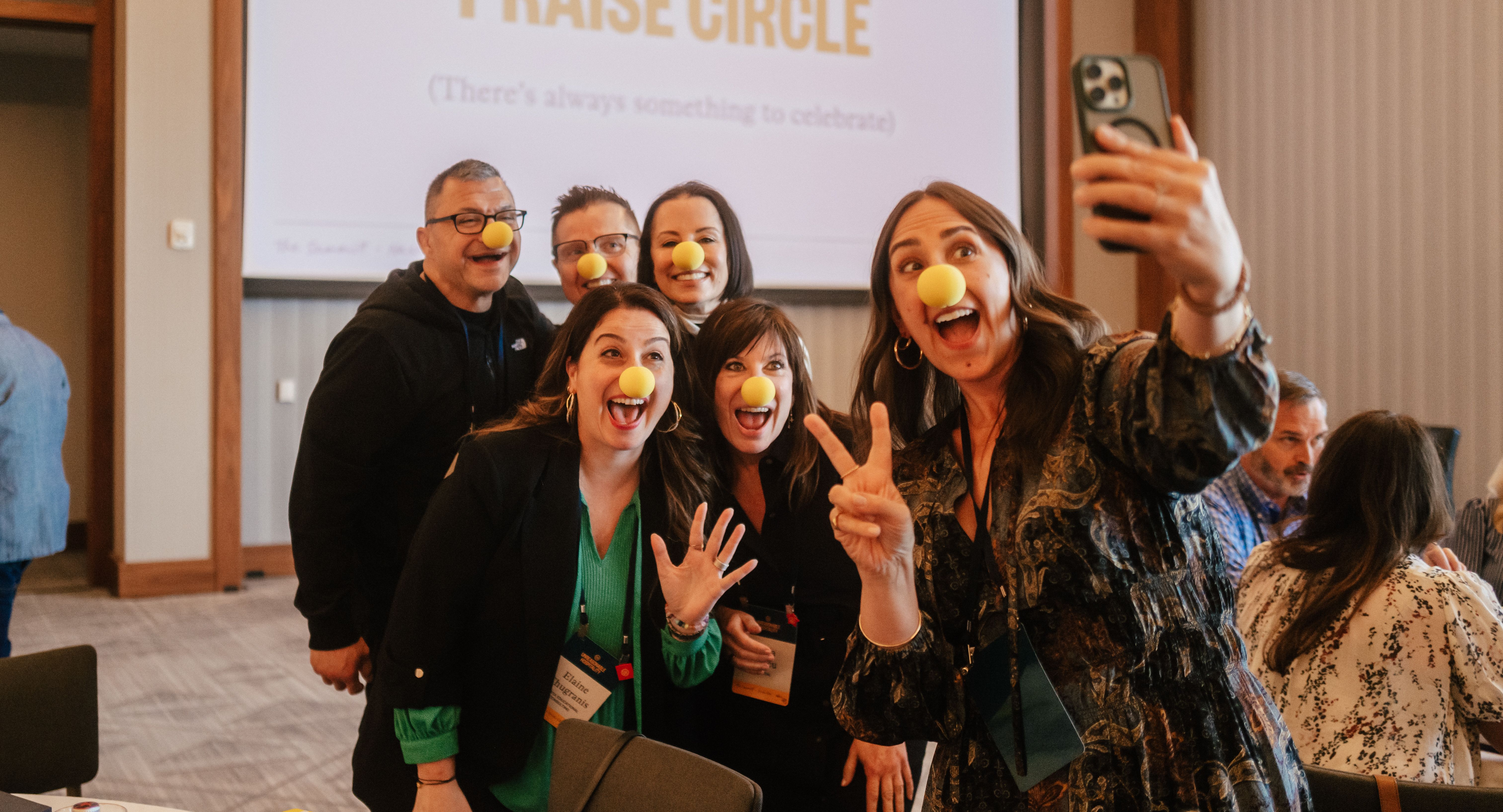 The Summit attendees posing for a selfie with clown noses