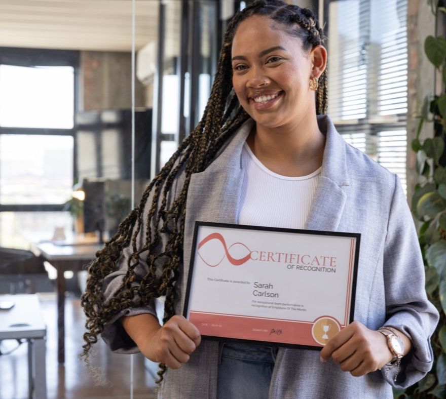 A learner holding a framed certificate
