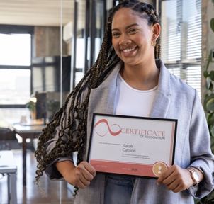 A learner holding a framed certificate