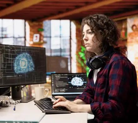 A learner working on a model at two screens