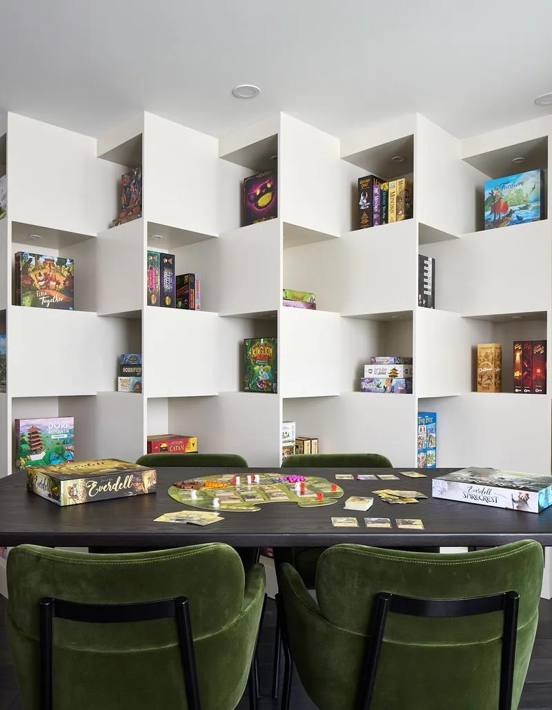 A wall of white shelving built to hold a games collection