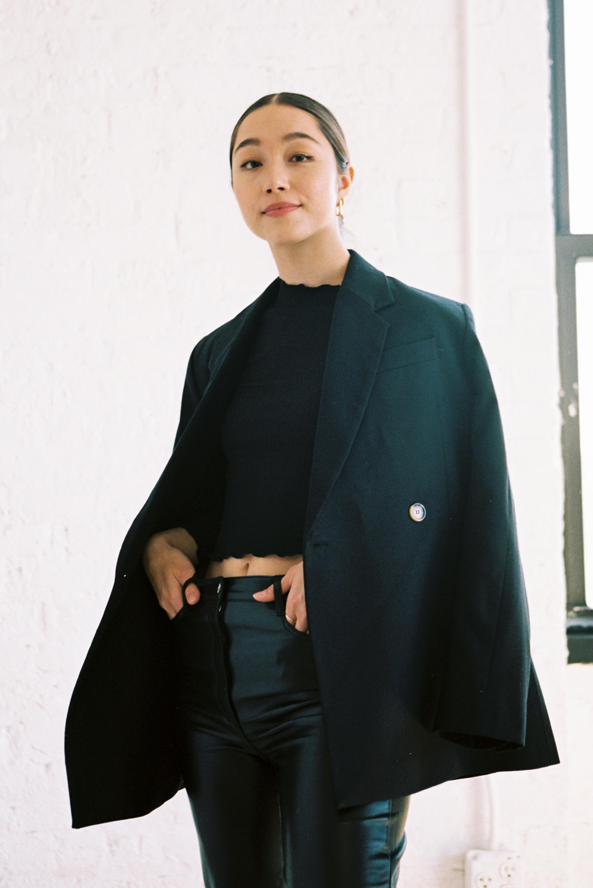 Stephanie Hon, the Founder and CEO of Cadence, standing confidently in a black blazer and pants in front of a window