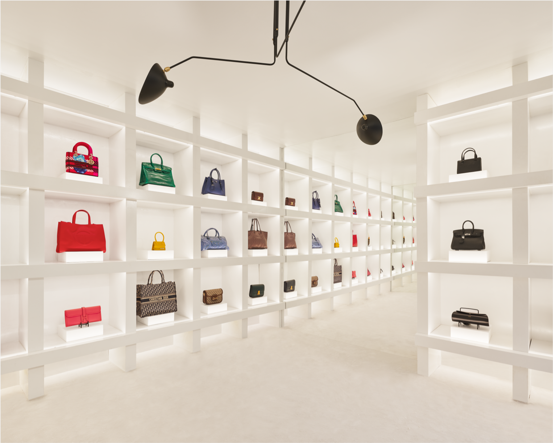 A collection of luxury handbags on display, including a prominently featured Dior bag, representing The RealReal's commitment to authenticity and sustainable fashion.