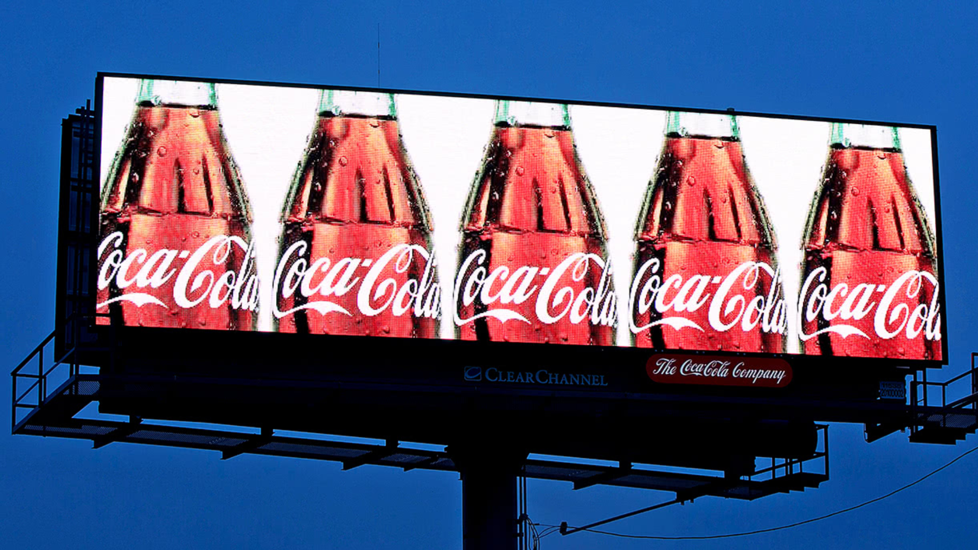 A Coca-Cola billboard displaying multiple bottles, symbolizing the brand's high unaided awareness and effective marketing strategy.