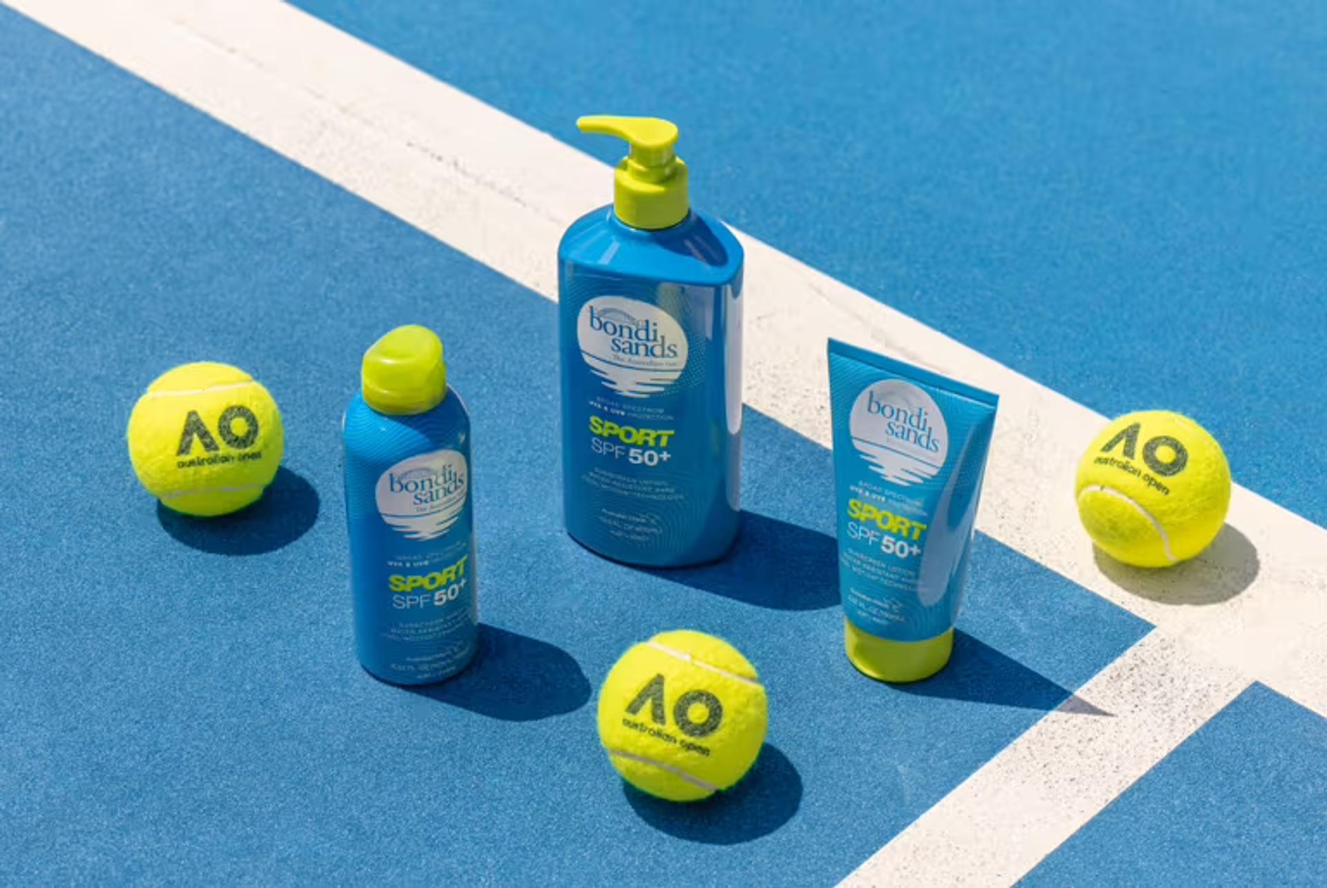 Tennis court featuring tennis balls and bottles of Bondi Sands sunscreen, symbolizing the brand's partnership with the Australian Open