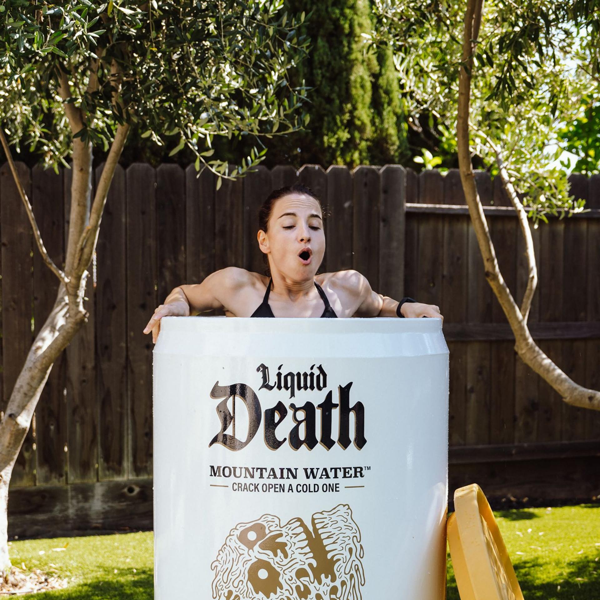 A woman swimming in an oversized can of Liquid Death, symbolizing the brand's bold and unconventional marketing strategies