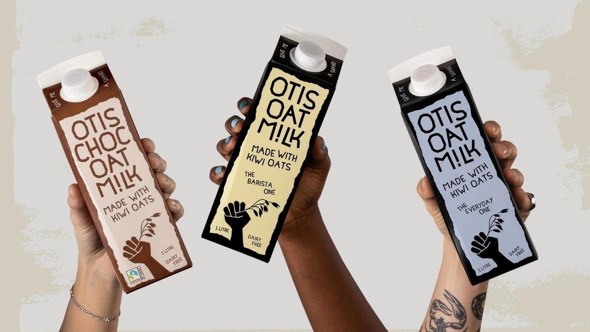 Three people holding bottles of oat milk for improving brand performance