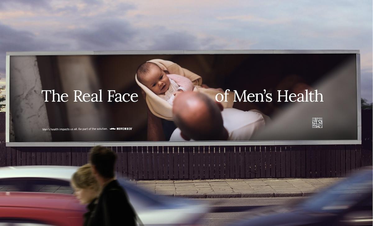 A billboard for the real face of men 's health shows a man holding a baby.