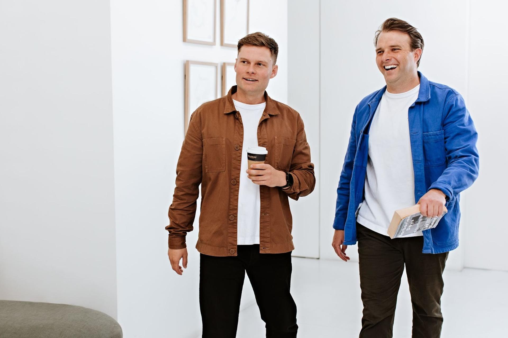 Co-CEOs of Tracksuit, Matt Herbert and Connor Archbold, standing together celebrating their company's successful seed funding round