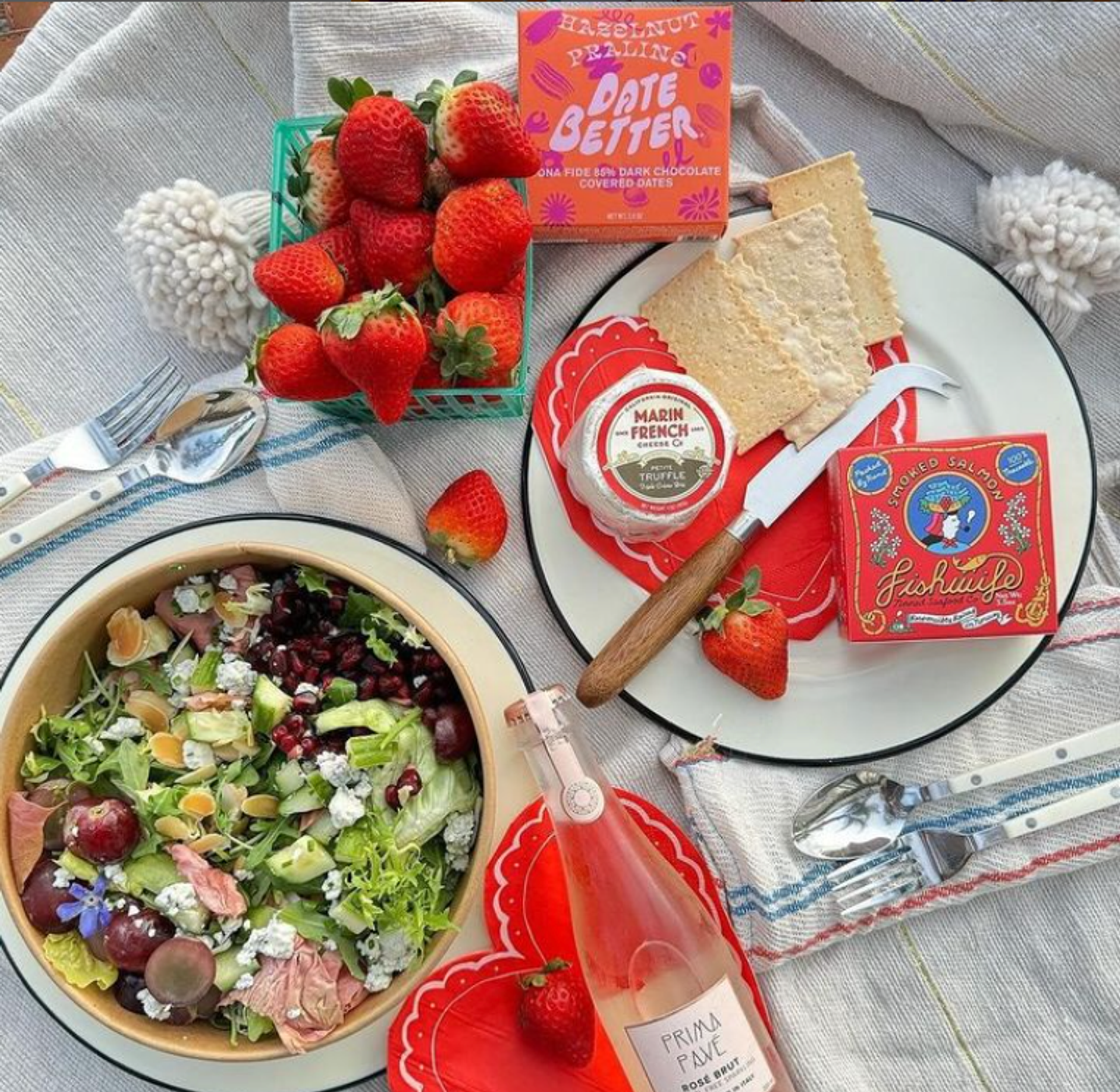 A bottle of Pruna fine wine placed on a table next to a fresh salad, representing a healthy and fine dining experience