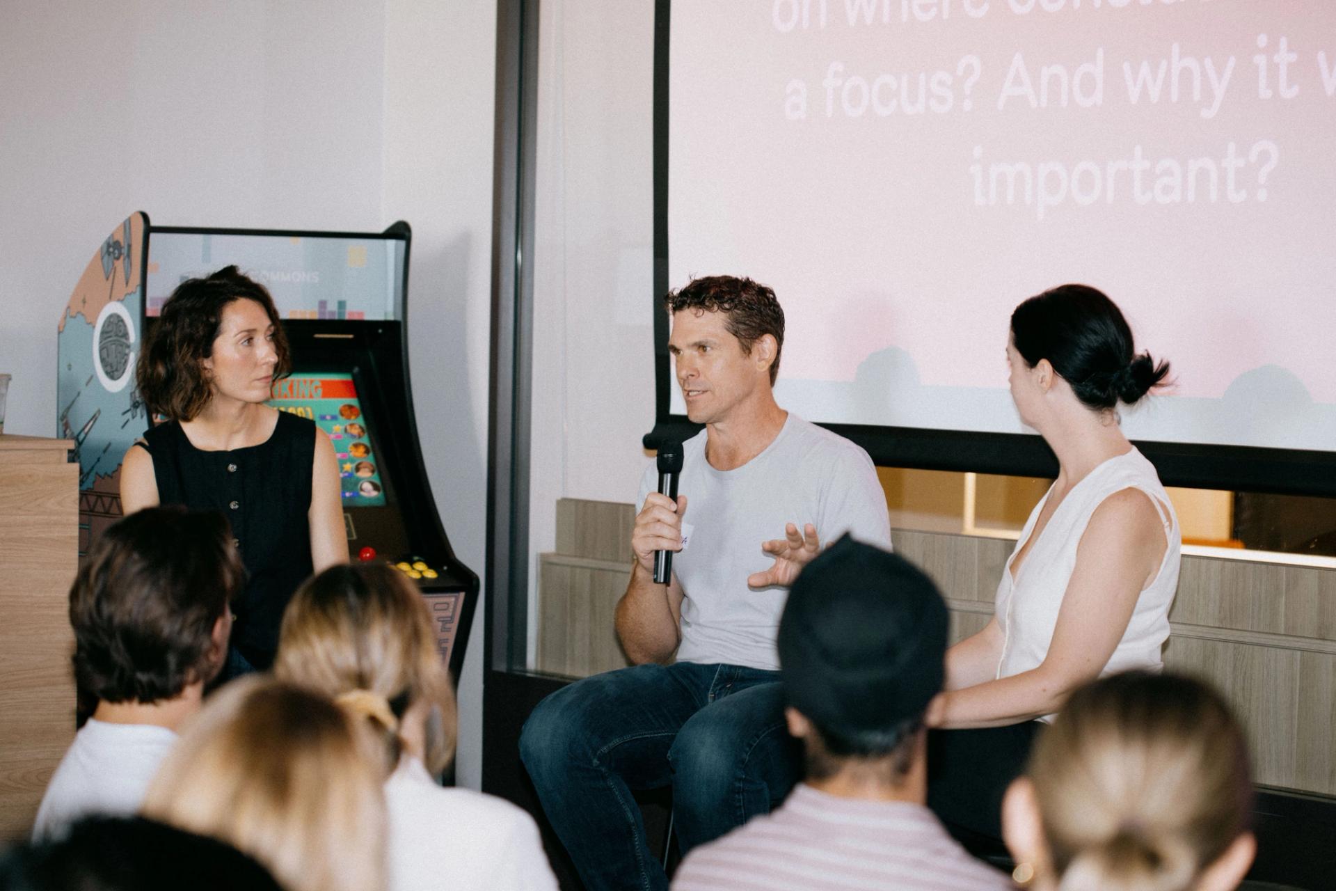 Matt Kowal, General Group Director of Naked Life, holding a microphone and discussing brand marketing strategies at a Tracksuit event