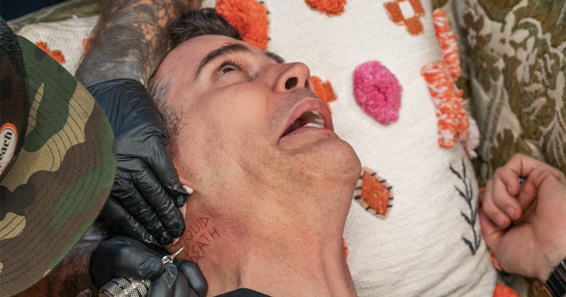 Man getting a tattoo, symbolizing the edgy and rebellious branding of Liquid Death, a bottled water company discussed in the article about the competitive bottled water industry.