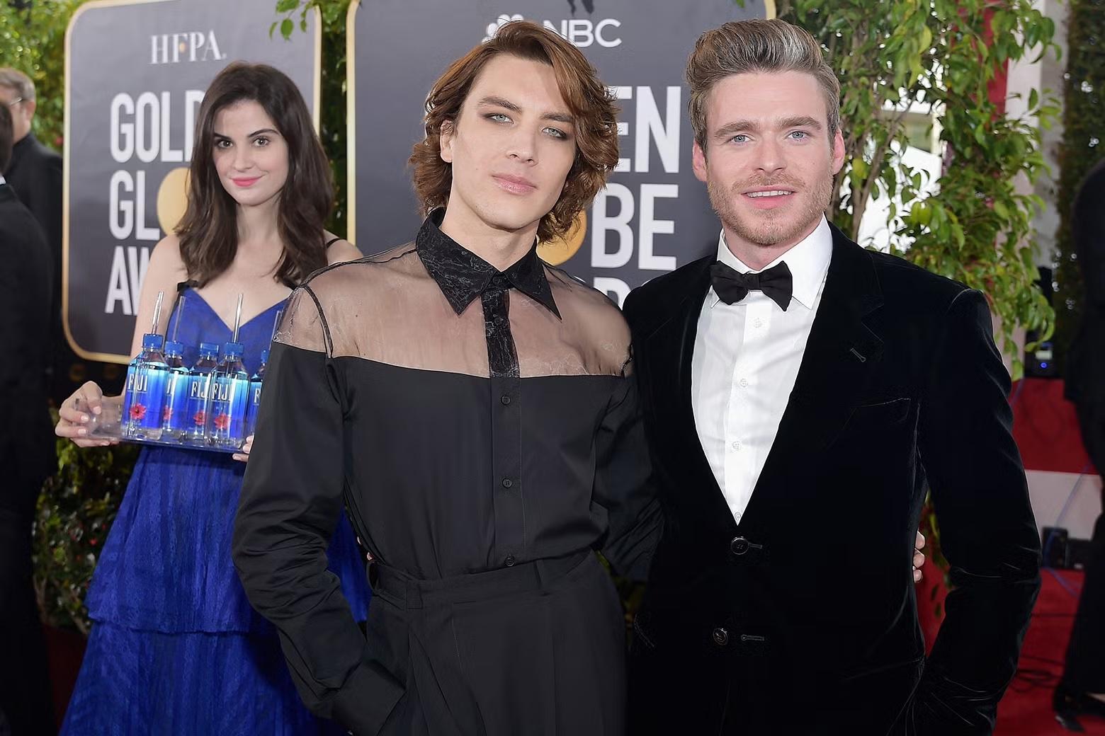Two men standing on a red carpet at an event, symbolizing Fiji Water's marketing strategy of sponsoring major events and associating with celebrities for brand recognition.