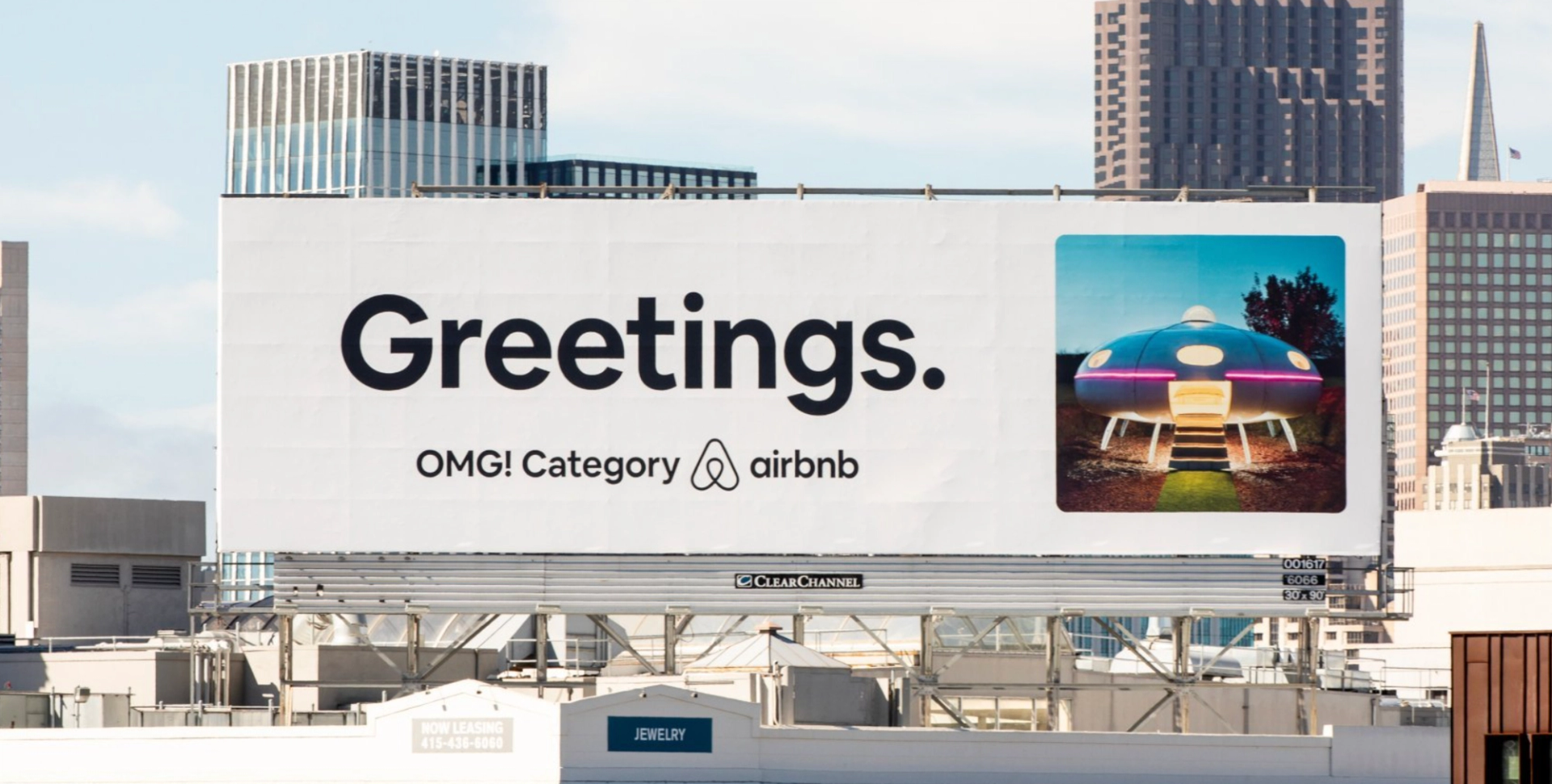 A minimalist billboard by Airbnb displaying the text 'Greetings.' Omg! category Airbnb, representing the company's innovative and brand-centric marketing strategy.