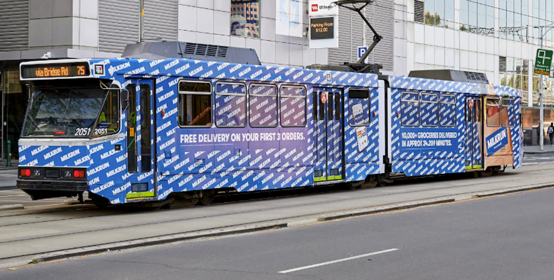 A tram advertising MILKRUN's offer of free delivery on the first two orders, promoting the brand's ultra-fast grocery delivery service in Australia.