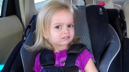 A little girl making a funny face while sitting in a car seat