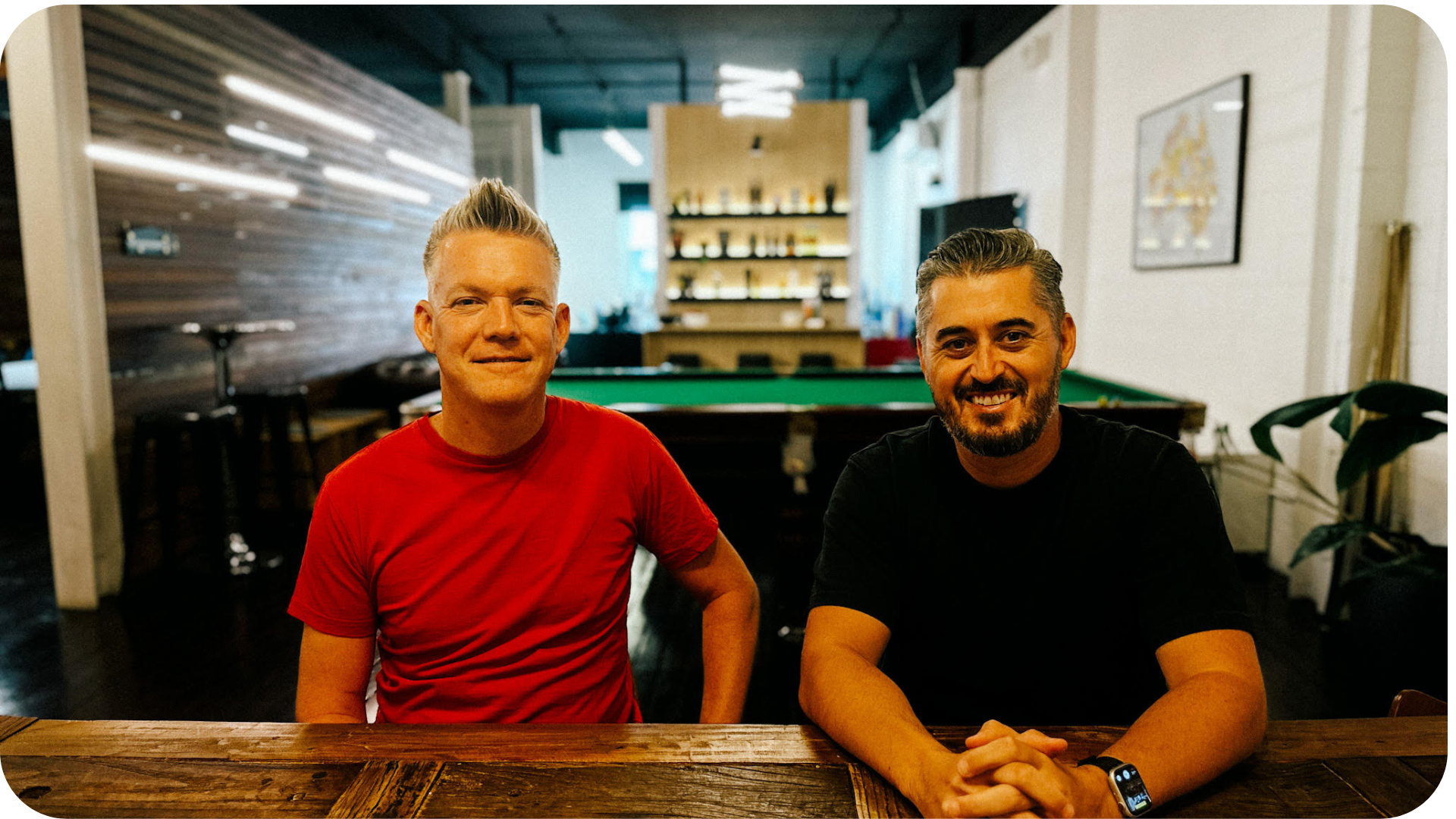 Two men, possibly Matt Robinson and Chief Strategy Officer Ben Hourahine of AnalogFolk Australia, sitting at a table discussing strategies, with a pool table in the background, symbolizing their strategic and game-changing approach in the digital marketing world.
