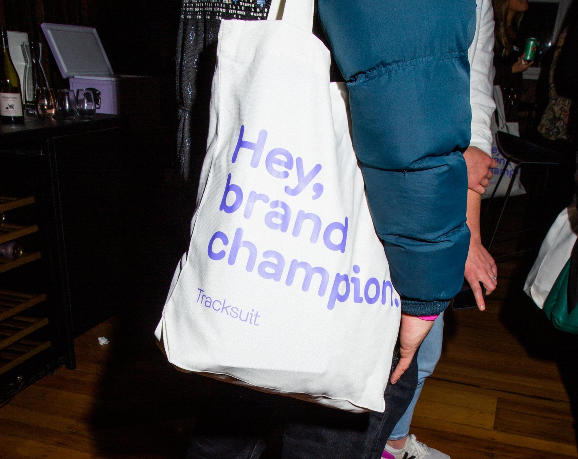 A white tote bag that says `Hey, brand champion'.