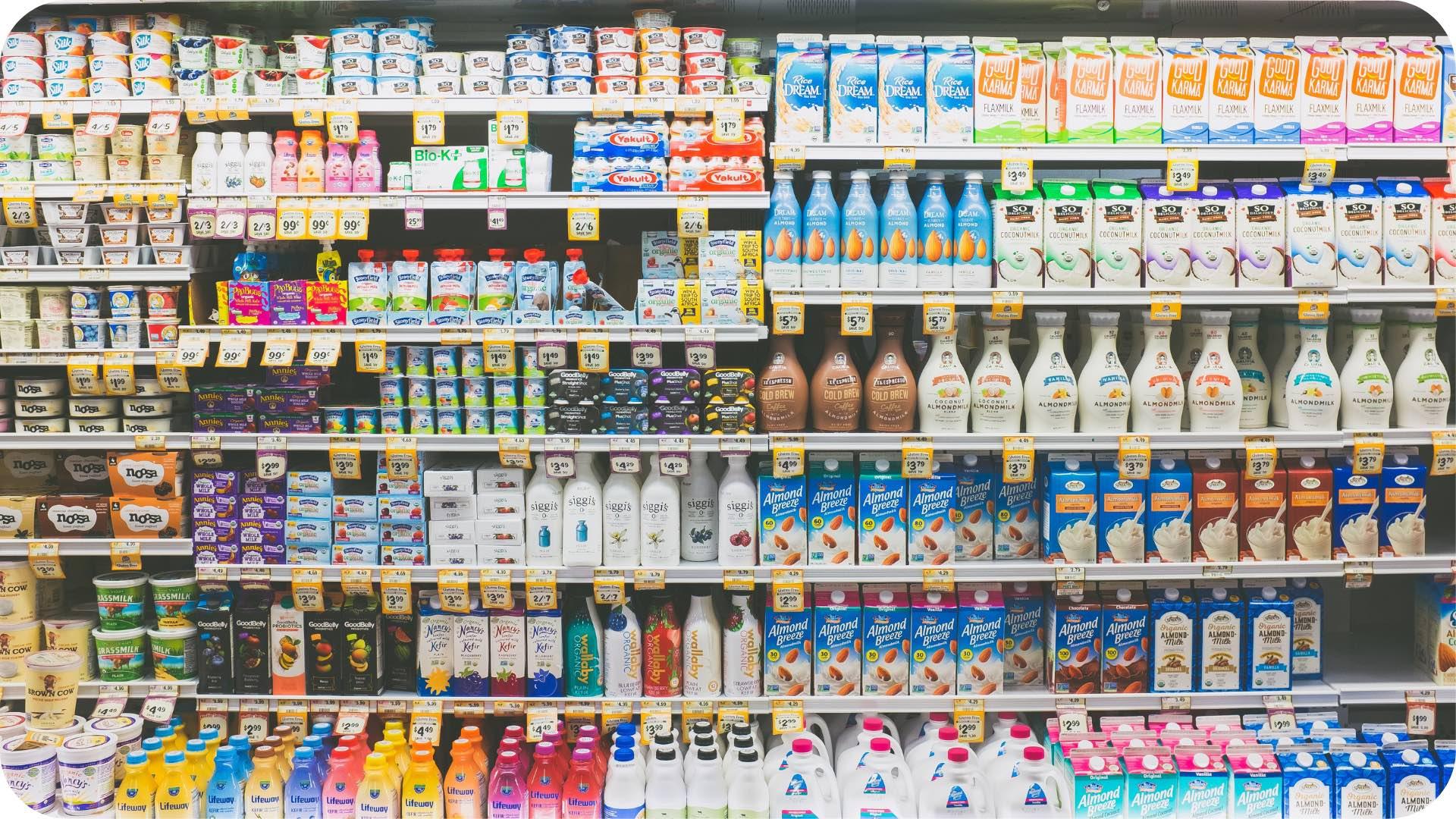 A grocery store aisle showcasing a variety of milk brands, illustrating the concept of brand competition and shelf space in retail environments.