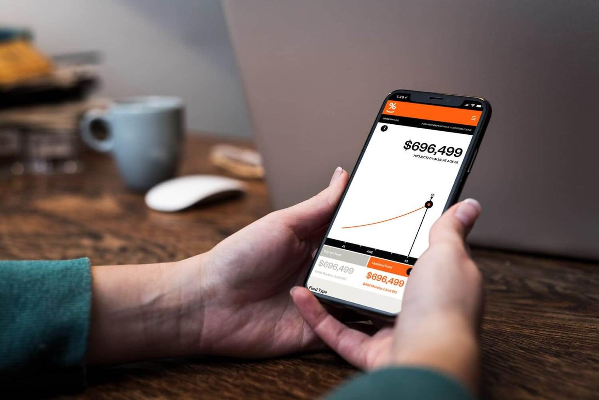 A person is holding a cell phone with a graph on the screen.