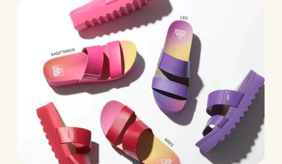 A pair of Reef Vista Hi sandals, part of a limited edition collection in collaboration with Sanctuary, designed for the zodiac signs Sagittarius, Leo, and Aries. The sandals represent Reef's brand evolution towards stylish and comfortable footwear.