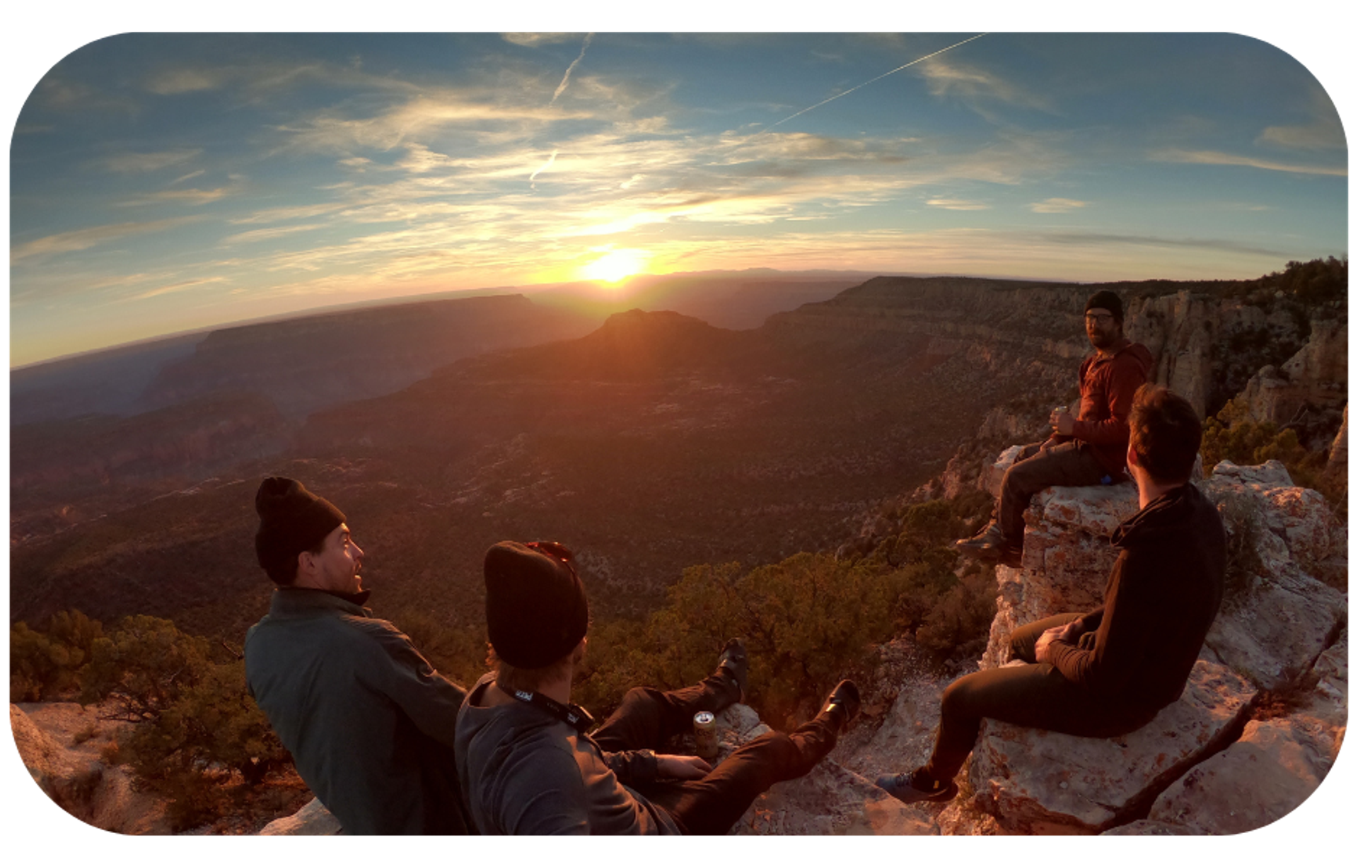 A group of brand ambassadors sitting on top of a mountain at sunset, symbolizing the peak of success in ambassador programs