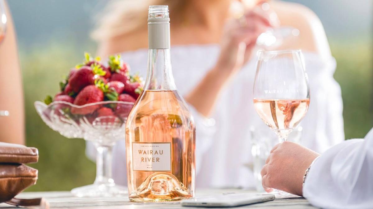 A bottle of Wairau River wine displayed on a table alongside a bowl of fresh strawberries, symbolizing the brand's physical and mental availability in the market