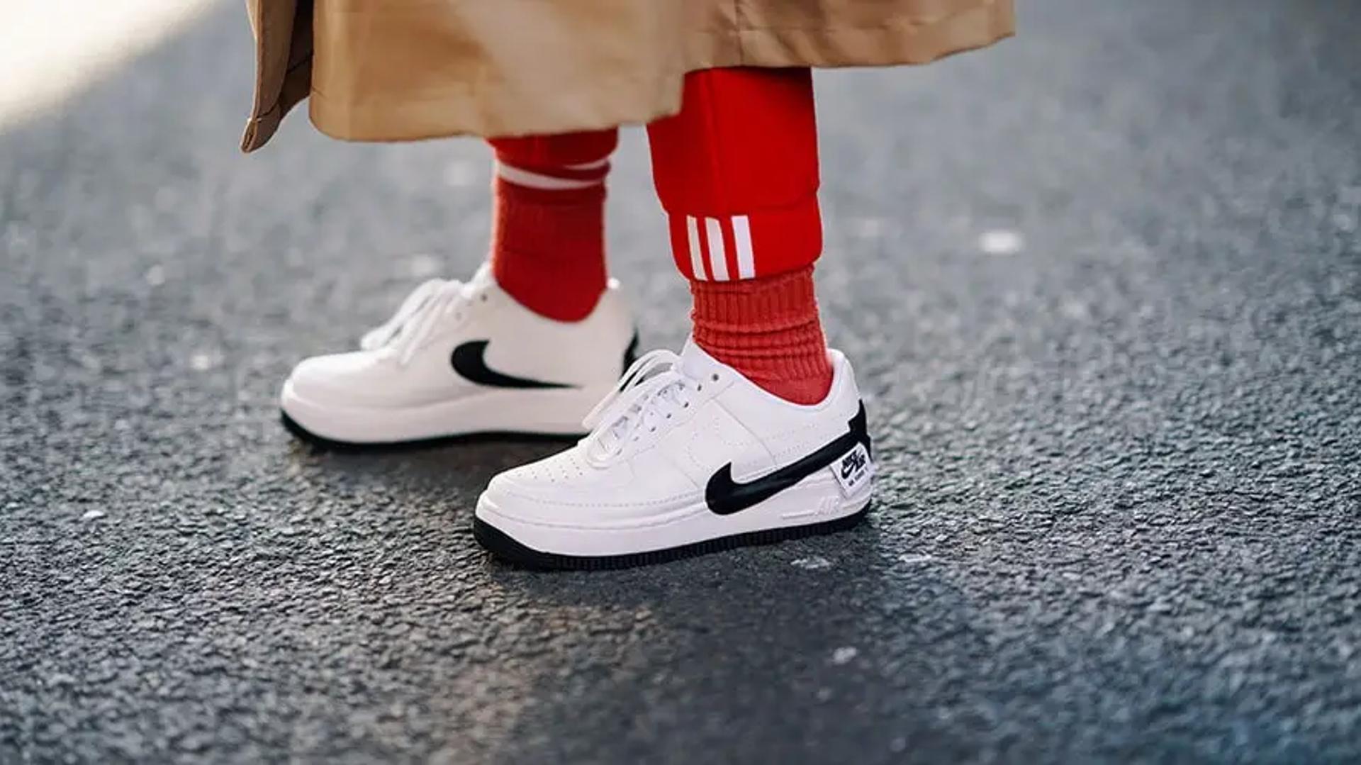A person wearing red socks and white nike sneakers.