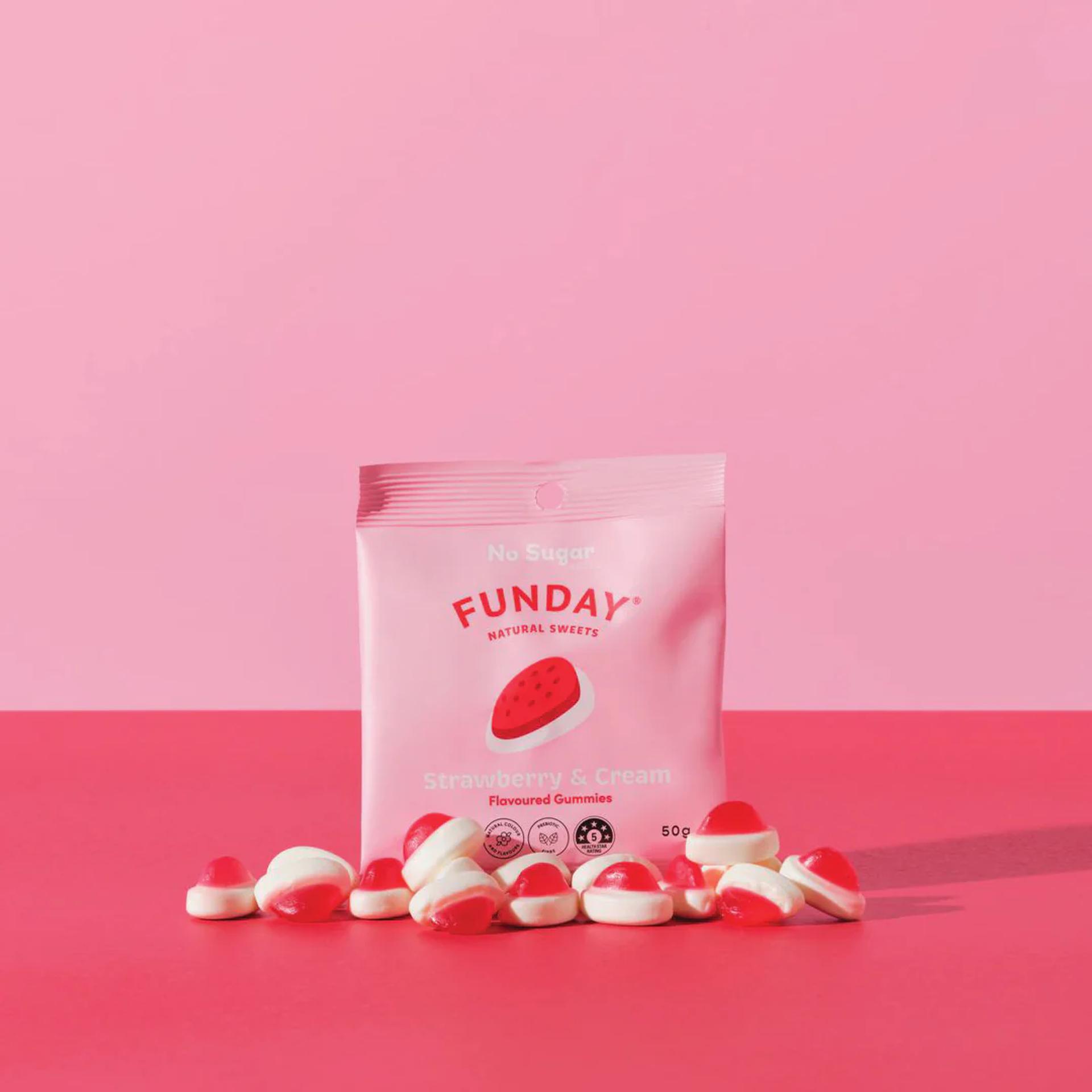 A bag of FUNDAY's strawberry and cream flavored gummies, a healthier confectionery option with natural ingredients, on a pink table.