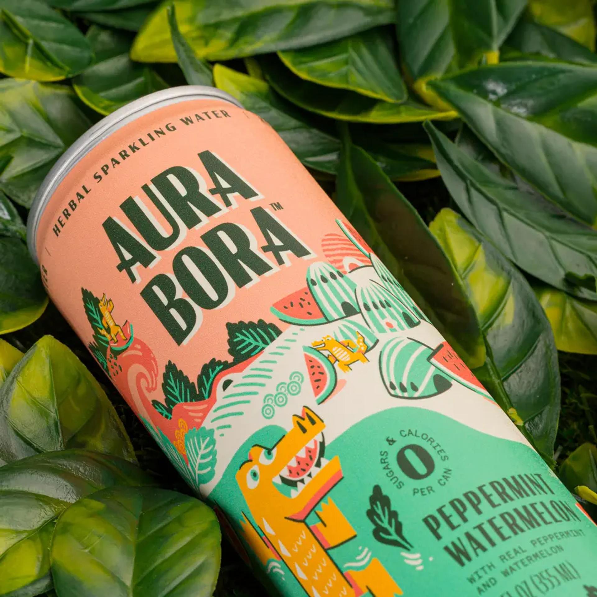 A can of Aura Bora Herbal Sparkling Water, a consumer packaged good, placed on a pile of leaves.