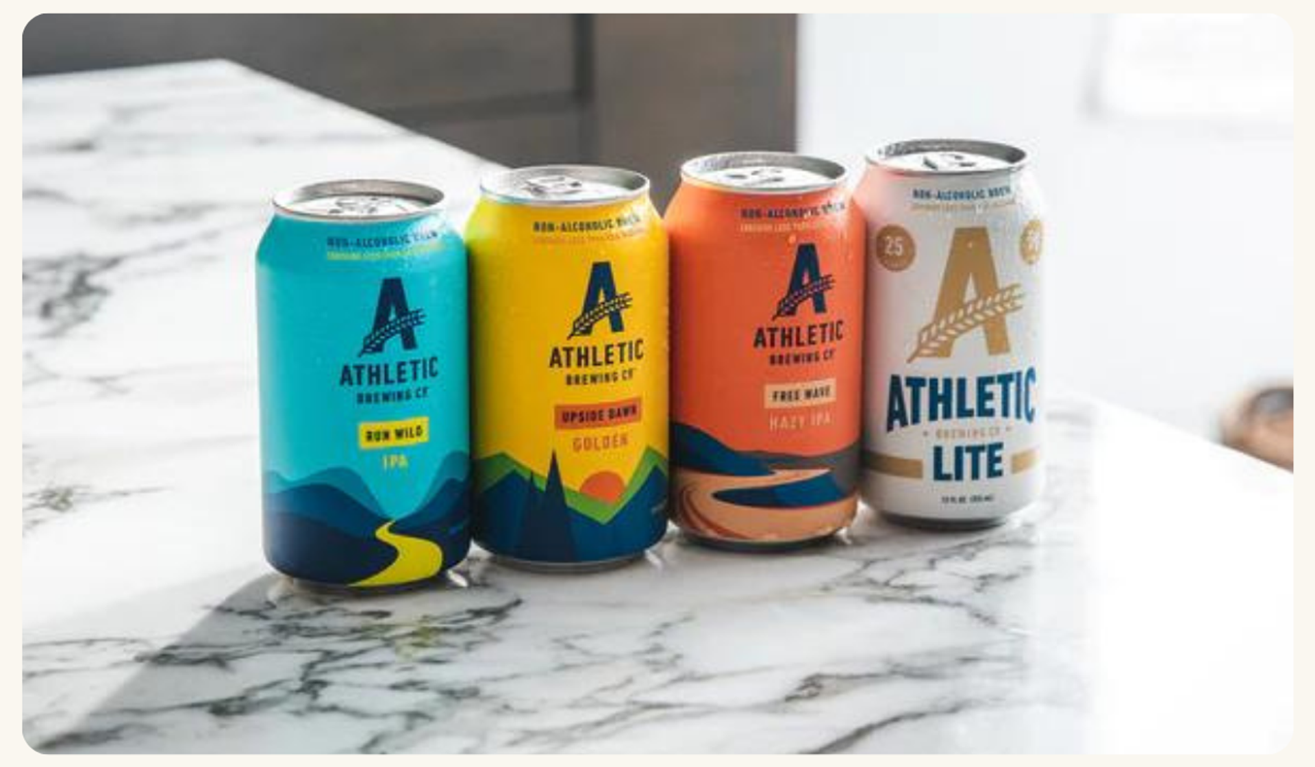 Four cans of Athletic Brewing Company's beer displayed on a counter, a brand monitored by Tracksuit's marketing tool